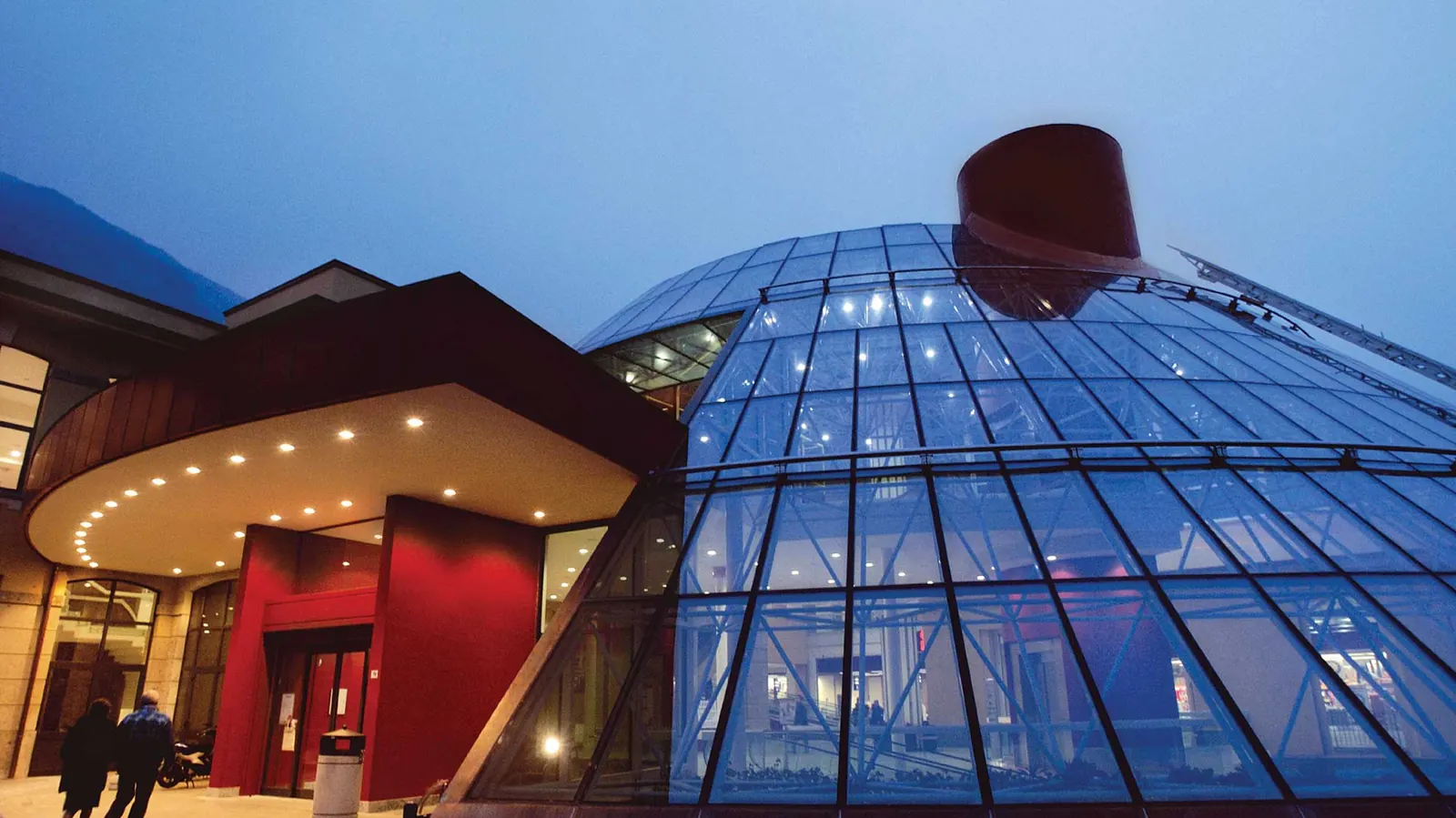Centro integrato Italmark a Villanuova sul Clisi: cupola vetrata illuminata e ingresso rosso, di sera