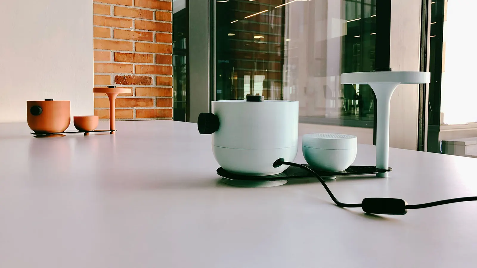 Sherlock in versione chiara: base tattile e diffusore audio su un tavolo bianco