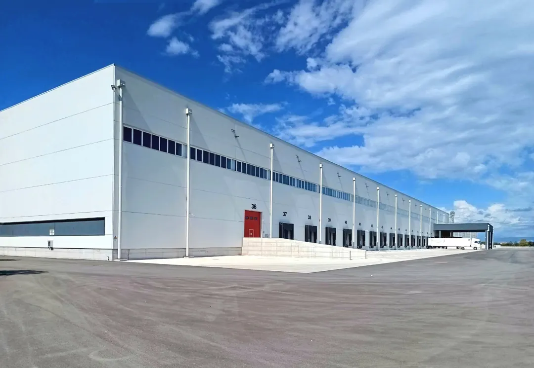 Piattaforma logistica bianca con baie di carico e piazzale