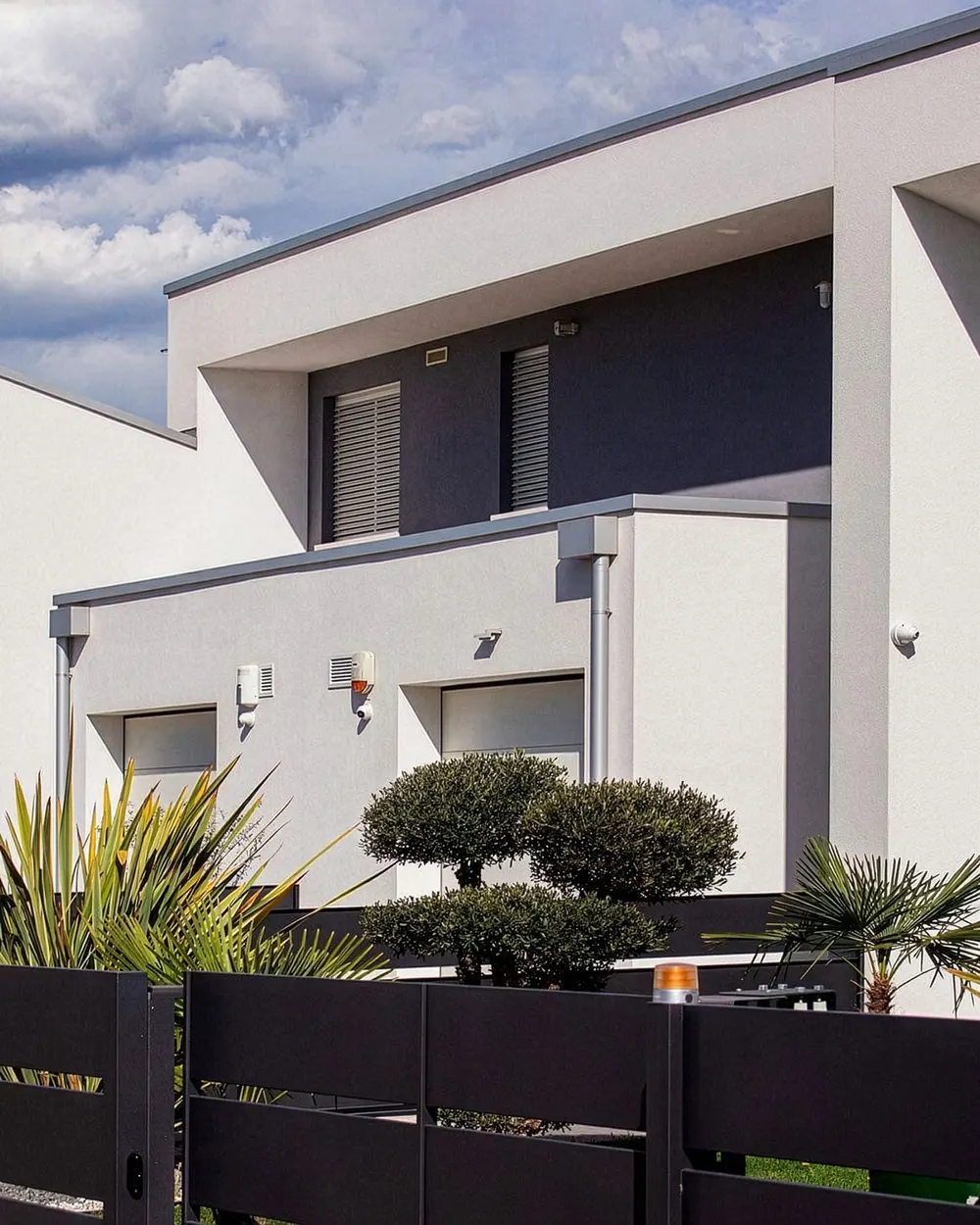 Theico: residenze contemporanee bianche a volumi squadrati con recinzioni scure
