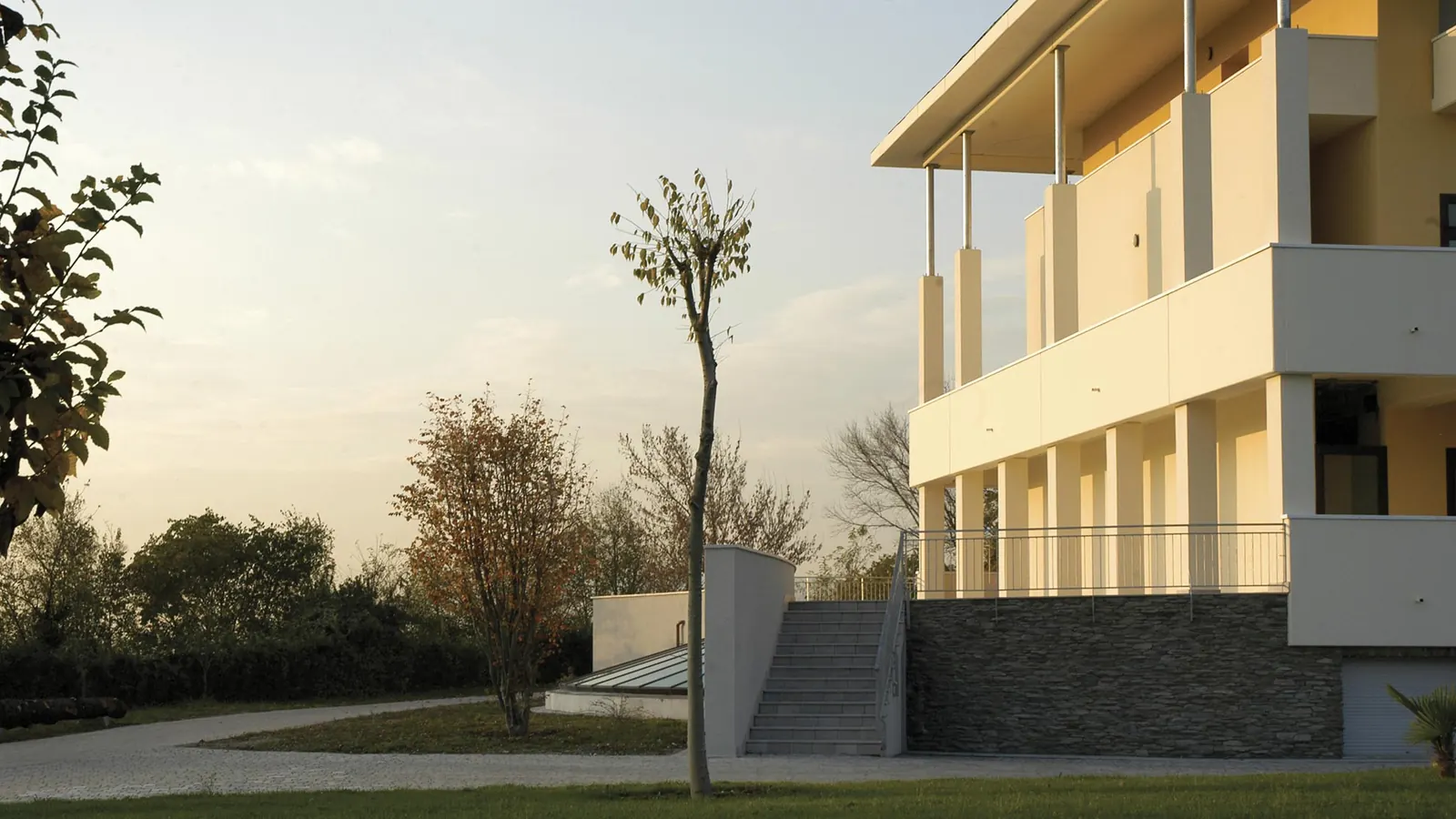 Comunità missionaria di Villaregia: edificio residenziale con logge bianche e giardino, al tramonto